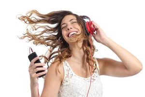 Happy girl dancing and listening to the music isolated on a white background